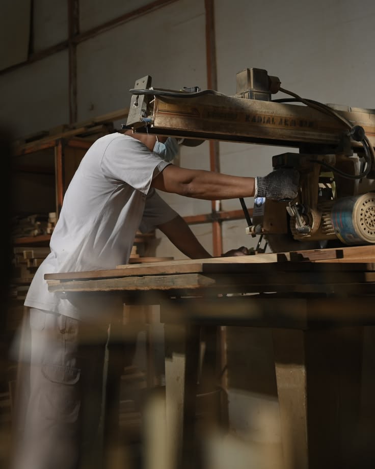 Woodworker operating a saw at a timber workbench